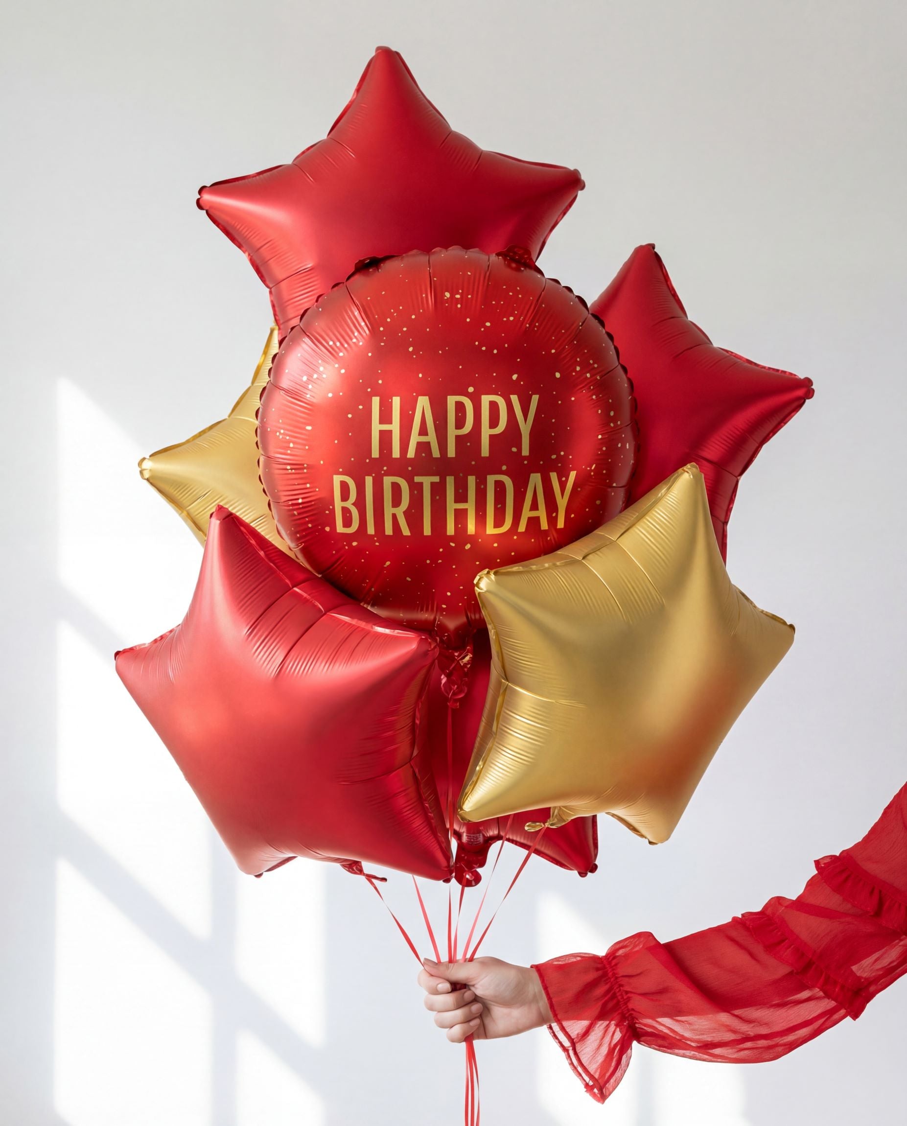 A stunning balloon bouquet featuring the red Happy Birthday foil surrounded by red and gold star-shaped balloons.
