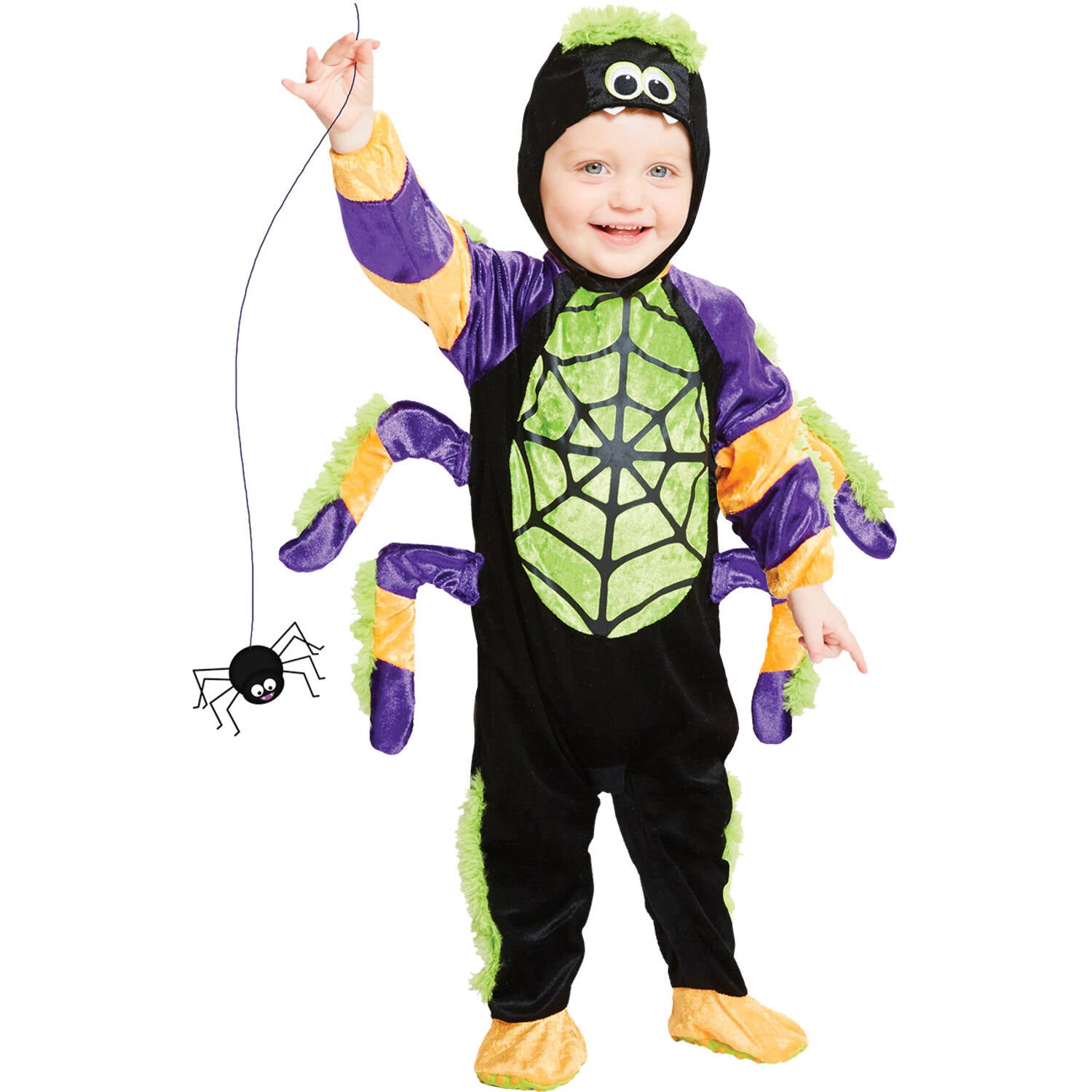 A smiling toddler standing playfully in a cute spooky spider Halloween costume, wearing a black plush romper with a green web print, attached purple and orange striped legs, and a matching black hood with cartoon eyes and tiny fangs.