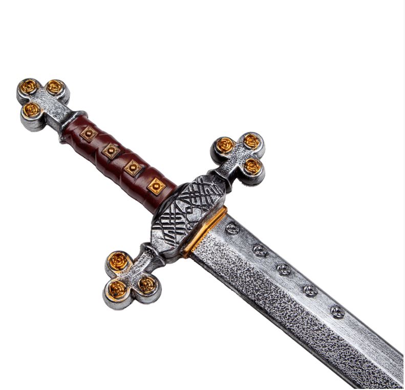 A close-up of the ornate hilt of a toy medieval warrior sword, showing a textured silver crossguard and pommel with gold rose accents, and a brown leather-look grip with gold studs.