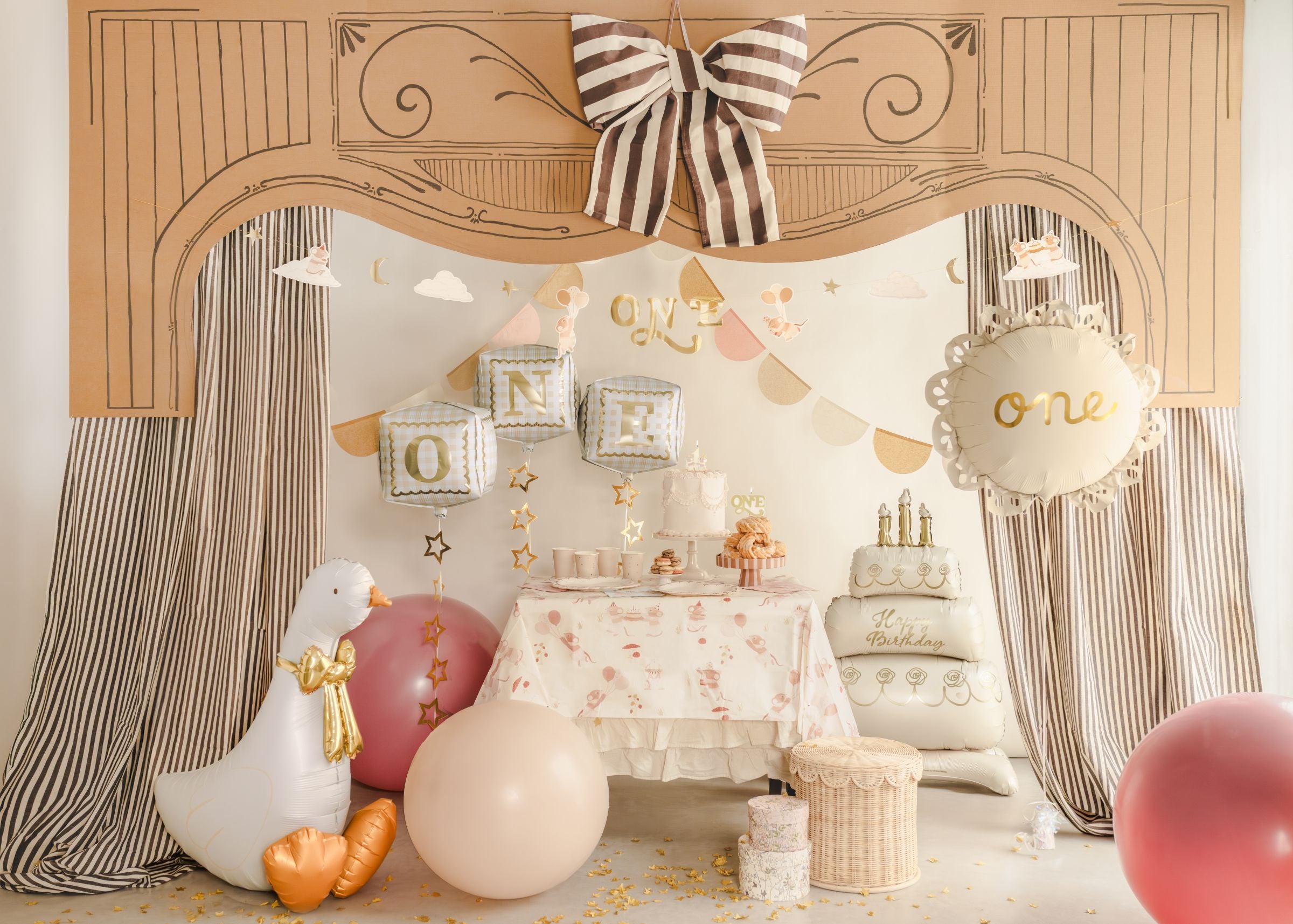 A grand 1st birthday party setup featuring a dessert table, a giant plush goose, and three 3D cube balloons spelling 'ONE' floating above.