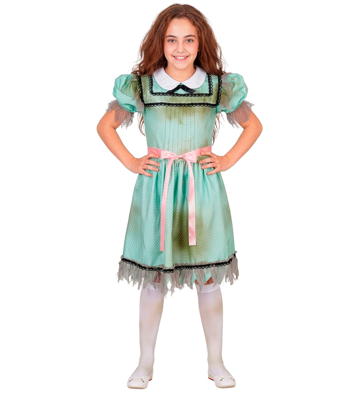 A young girl smiling while wearing a vintage green polka dot dress with distressed details, a pink belt, and white knee-high socks.