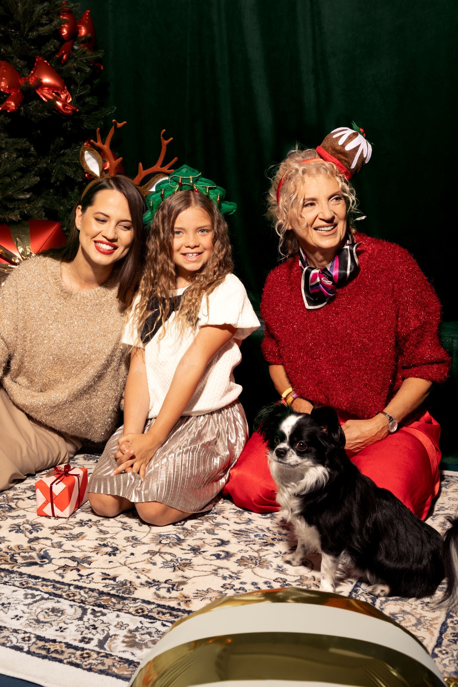 A family in a Christmas-themed photo, with one woman on the left wearing the brown reindeer antler headband.