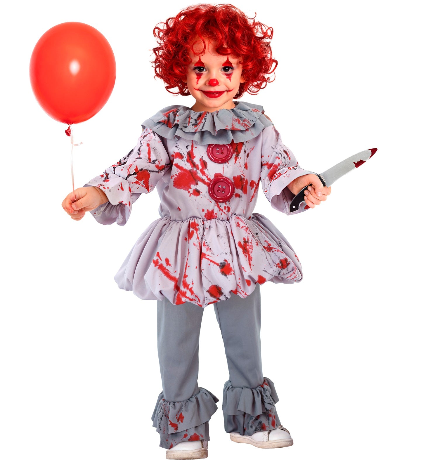 A toddler child in a "killer clown" style costume, with a red curly wig and clown makeup, holding a red balloon and a toy knife, posing on a white background. The costume includes a grey ruffled tunic with red blood splatter stains and grey trousers with ruffled cuffs.
