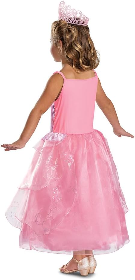 The back view of the child's Glinda costume, showing the full, flowing, tiered pink skirt and a prop crown.