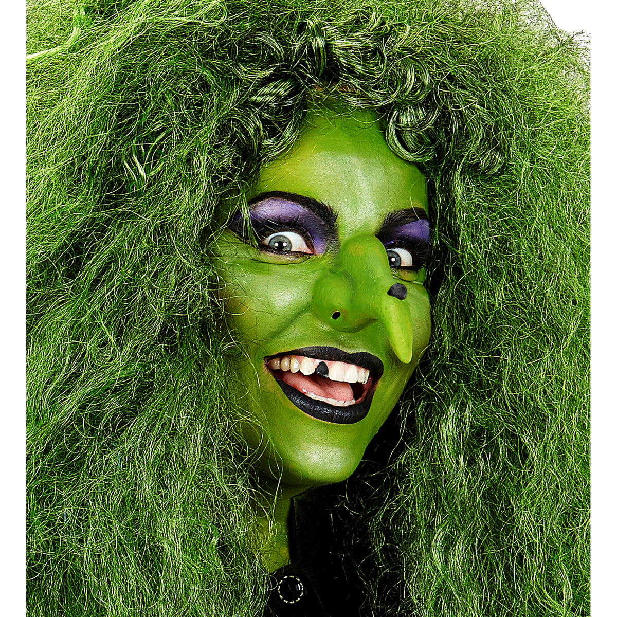 A woman styled as a classic wicked witch with wild green hair, a prosthetic nose with a wart, and full green face makeup with a blacked-out tooth.
