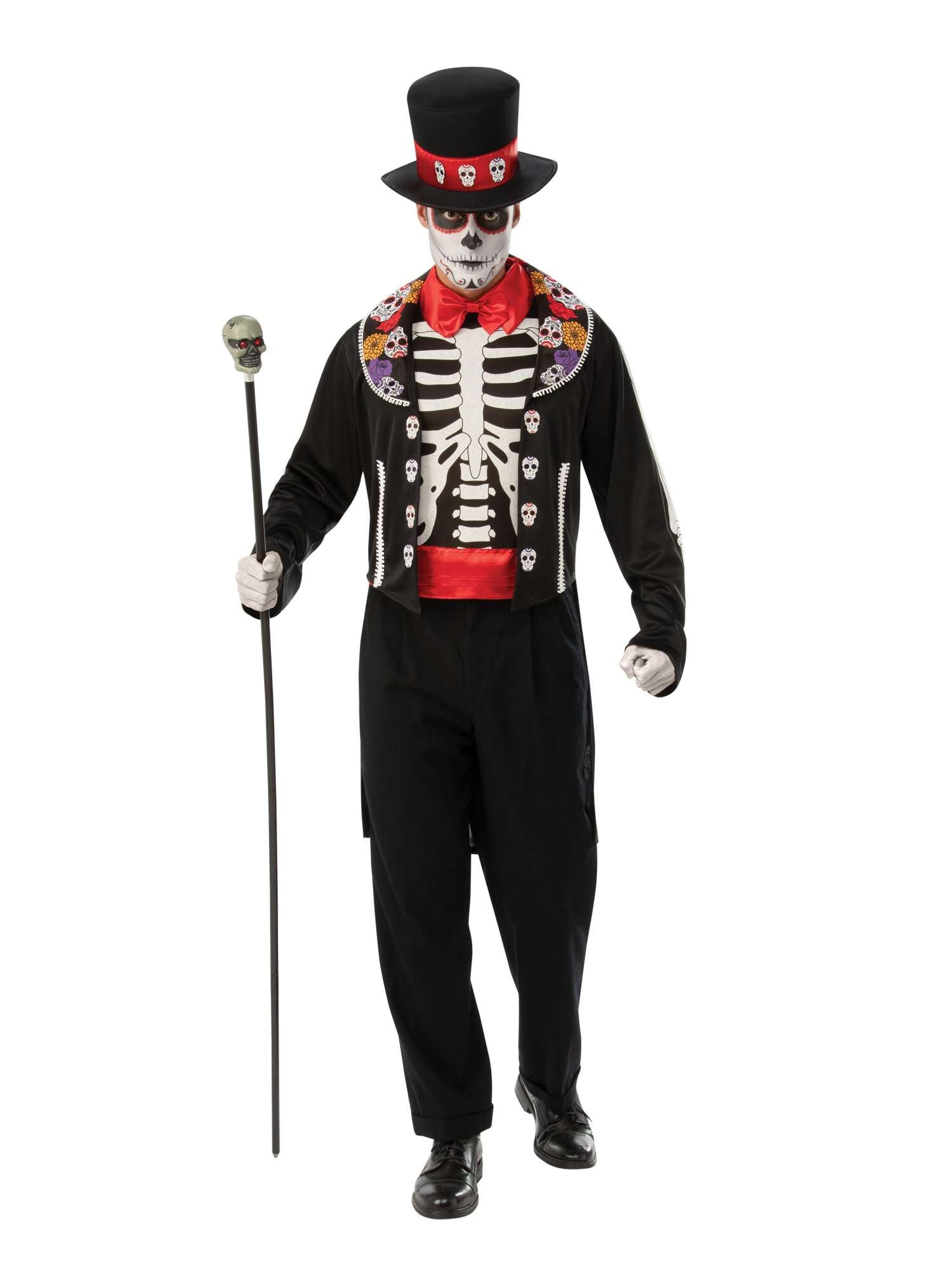 A man in a Day of the Dead themed costume, with a painted face resembling a sugar skull. He is wearing a black tailcoat with a colorful skull and floral design, a skeleton-printed shirt, a red bow tie and sash, black trousers, and a black top hat with red and skull details. He is holding a walking stick with a skull on top.