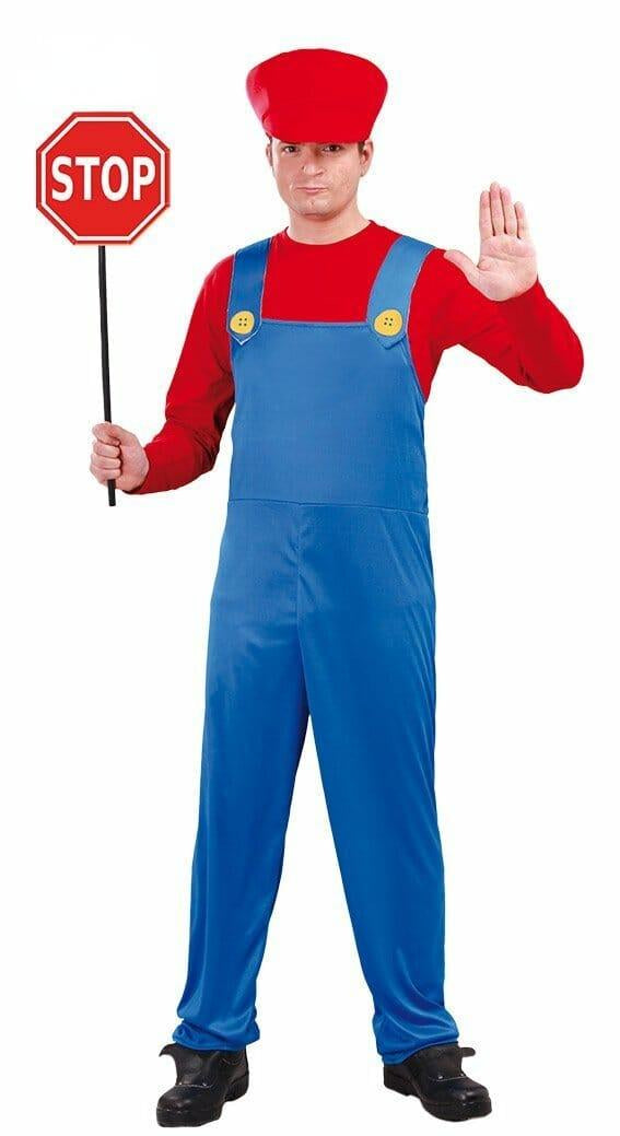 A male model wearing a retro video game-inspired funny train operator costume, featuring a bright red long-sleeved shirt under blue overalls with yellow buttons and a matching red cap, holding a red stop sign.